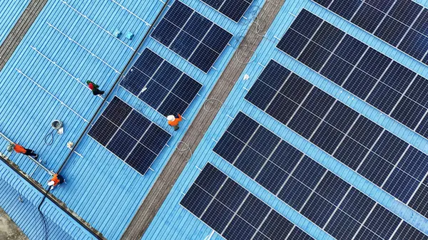 Hava manzarası, güneş panelleri büyük bir binanın çatısına kurulmuş. Güneş pili çiftliği enerji santrali eko teknolojisi. Bir fotovoltaik enerji santralindeki güneş pili panellerinin peyzajı