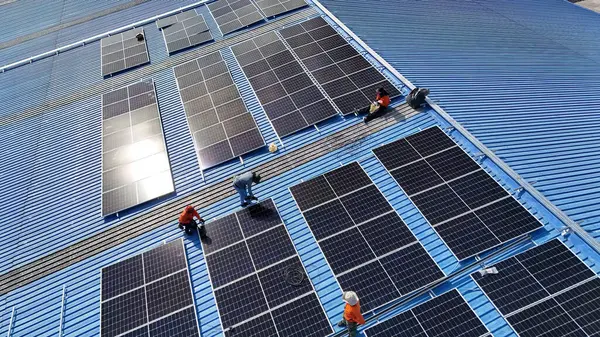 Hava manzarası, güneş panelleri büyük bir binanın çatısına kurulmuş. Güneş pili çiftliği enerji santrali eko teknolojisi. Bir fotovoltaik enerji santralindeki güneş pili panellerinin peyzajı