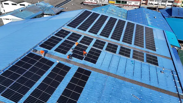 Hava manzarası, güneş panelleri büyük bir binanın çatısına kurulmuş. Güneş pili çiftliği enerji santrali eko teknolojisi. Bir fotovoltaik enerji santralindeki güneş pili panellerinin peyzajı