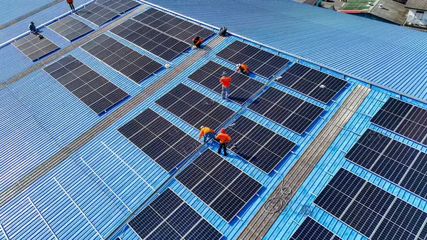 Hava manzarası, güneş panelleri büyük bir binanın çatısına kurulmuş. Güneş pili çiftliği enerji santrali eko teknolojisi. Bir fotovoltaik enerji santralindeki güneş pili panellerinin peyzajı