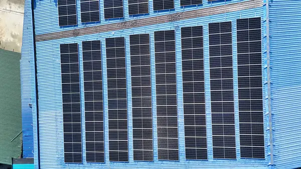 Hava manzarası, güneş panelleri büyük bir binanın çatısına kurulmuş. Güneş pili çiftliği enerji santrali eko teknolojisi. Bir fotovoltaik enerji santralindeki güneş pili panellerinin peyzajı