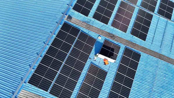 Hava manzarası, güneş panelleri büyük bir binanın çatısına kurulmuş. Güneş pili çiftliği enerji santrali eko teknolojisi. Bir fotovoltaik enerji santralindeki güneş pili panellerinin peyzajı