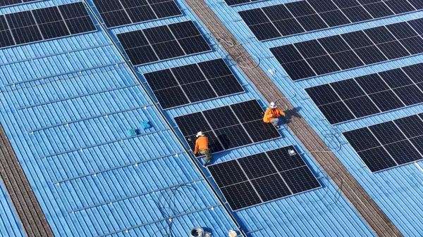 Hava manzarası, güneş panelleri büyük bir binanın çatısına kurulmuş. Güneş pili çiftliği enerji santrali eko teknolojisi. Bir fotovoltaik enerji santralindeki güneş pili panellerinin peyzajı