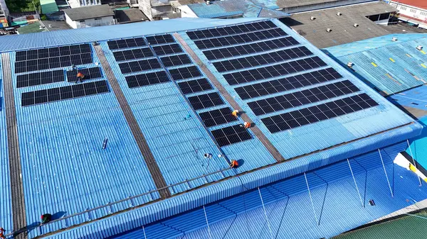 Hava manzarası, güneş panelleri büyük bir binanın çatısına kurulmuş. Güneş pili çiftliği enerji santrali eko teknolojisi. Bir fotovoltaik enerji santralindeki güneş pili panellerinin peyzajı