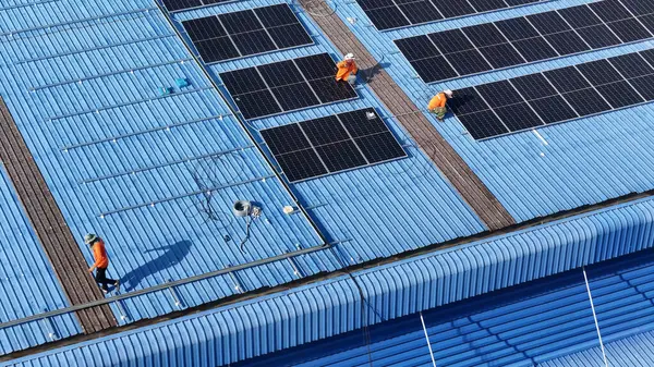Hava manzarası, güneş panelleri büyük bir binanın çatısına kurulmuş. Güneş pili çiftliği enerji santrali eko teknolojisi. Bir fotovoltaik enerji santralindeki güneş pili panellerinin peyzajı