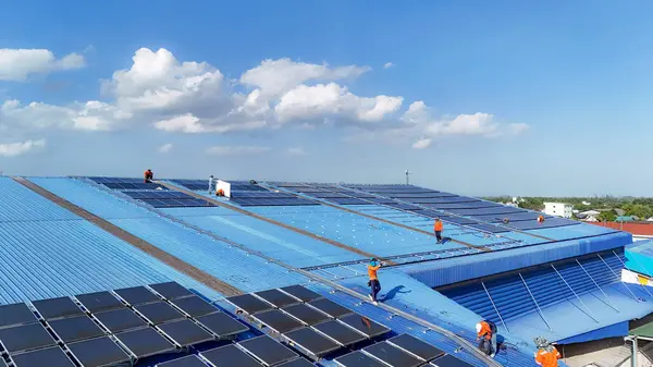 Hava manzarası, güneş panelleri büyük bir binanın çatısına kurulmuş. Güneş pili çiftliği enerji santrali eko teknolojisi. Bir fotovoltaik enerji santralindeki güneş pili panellerinin peyzajı