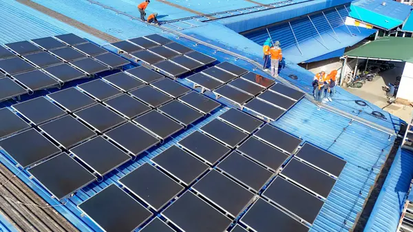 Hava manzarası, güneş panelleri büyük bir binanın çatısına kurulmuş. Güneş pili çiftliği enerji santrali eko teknolojisi. Bir fotovoltaik enerji santralindeki güneş pili panellerinin peyzajı