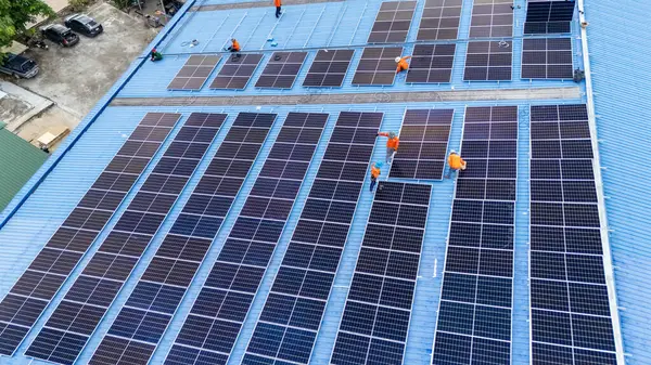 Hava manzarası, güneş panelleri büyük bir binanın çatısına kurulmuş. Güneş pili çiftliği enerji santrali eko teknolojisi. Bir fotovoltaik enerji santralindeki güneş pili panellerinin peyzajı