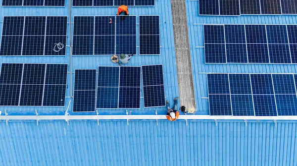 Hava manzarası, güneş panelleri büyük bir binanın çatısına kurulmuş. Güneş pili çiftliği enerji santrali eko teknolojisi. Bir fotovoltaik enerji santralindeki güneş pili panellerinin peyzajı