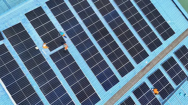 Hava manzarası, güneş panelleri büyük bir binanın çatısına kurulmuş. Güneş pili çiftliği enerji santrali eko teknolojisi. Bir fotovoltaik enerji santralindeki güneş pili panellerinin peyzajı