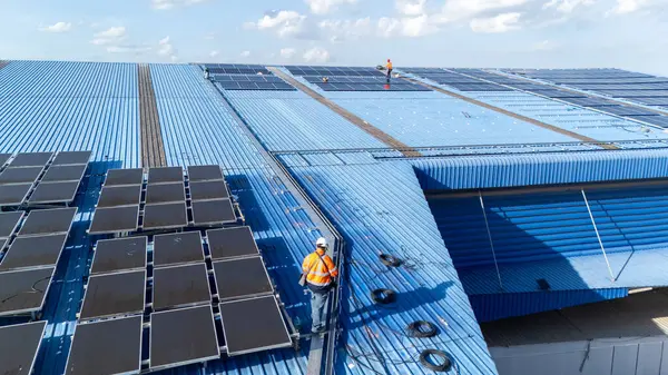 Hava manzarası, güneş panelleri büyük bir binanın çatısına kurulmuş. Güneş pili çiftliği enerji santrali eko teknolojisi. Bir fotovoltaik enerji santralindeki güneş pili panellerinin peyzajı