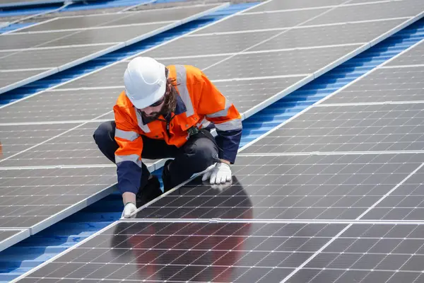 Erkek teknisyenler fotovoltaik güneş modüllerini evin çatısına monte ediyorlar. Yenilenebilir Enerji Eko Teknolojisi.
