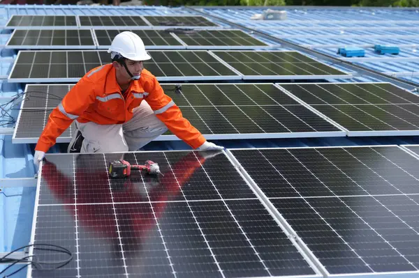Teknoloji güneş pili, mühendislik hizmeti kurulum güneş pili fabrika endüstrisinin çatısında. Fabrikanın çatısındaki güneş pilini inceleyen teknisyen. 