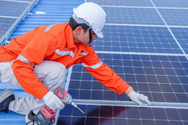Teknoloji güneş pili, mühendislik hizmeti kurulum güneş pili fabrika endüstrisinin çatısında. Fabrikanın çatısındaki güneş pilini inceleyen teknisyen. 