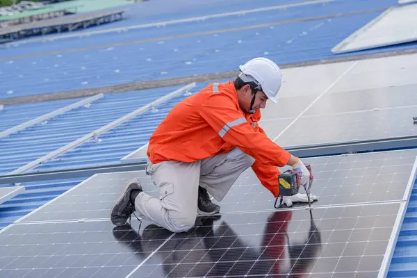 Teknoloji güneş pili, mühendislik hizmeti kurulum güneş pili fabrika endüstrisinin çatısında. Fabrikanın çatısındaki güneş pilini inceleyen teknisyen. 