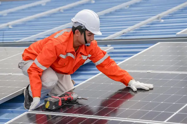 Teknoloji güneş pili, mühendislik hizmeti kurulum güneş pili fabrika endüstrisinin çatısında. Fabrikanın çatısındaki güneş pilini inceleyen teknisyen. 
