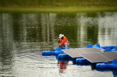 Fotovoltaik mühendisleri yüzen fotovoltaikler üzerinde çalışıyorlar. Güneş paneli ekipmanlarını incele ve onar