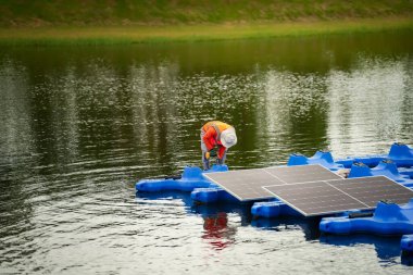 Fotovoltaik mühendisleri yüzen fotovoltaikler üzerinde çalışıyorlar. Güneş paneli ekipmanlarını incele ve onar