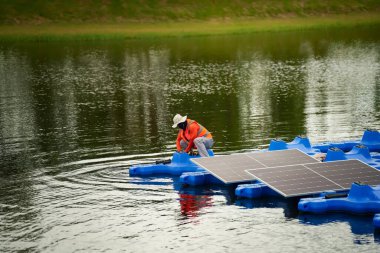 Fotovoltaik mühendisleri yüzen fotovoltaikler üzerinde çalışıyorlar. Güneş paneli ekipmanlarını incele ve onar. Fotovoltaik güneş panelleri kuran teknisyenler.