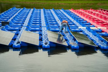 Fotovoltaik mühendisleri yüzen fotovoltaikler üzerinde çalışıyorlar. Güneş paneli ekipmanlarını incele ve onar. Fotovoltaik güneş panelleri kuran teknisyenler.