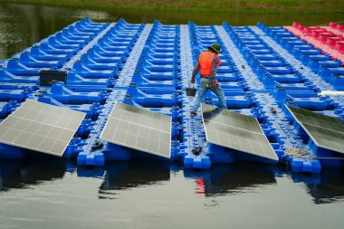 Fotovoltaik mühendisleri yüzen fotovoltaikler üzerinde çalışıyorlar. Güneş paneli ekipmanlarını incele ve onar. Fotovoltaik güneş panelleri kuran teknisyenler.