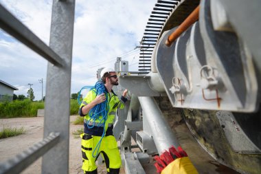 Rüzgar türbininin yenilenebilir enerji alanında güvenlik üniforması giyen bir mühendis. Teknoloji çevreyi korur küresel ısınma sorunlarını azaltır. alternatif enerji kavramı.