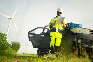 Rüzgar türbininin yenilenebilir enerji alanında güvenlik üniforması giyen bir mühendis. Teknoloji çevreyi korur küresel ısınma sorunlarını azaltır. alternatif enerji kavramı.