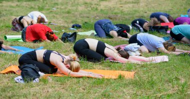 Şehir parkında yoga yapan bir grup kadın meditasyon yapıyor..