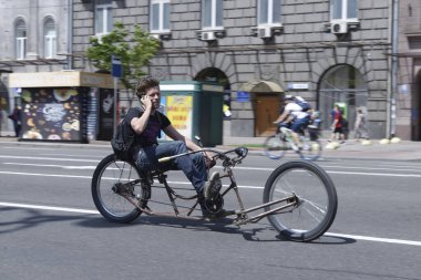 Sokak yolunda el yapımı bir bisikletle koşuşturan erkek bisikletçi. Kiev Günü 'ne adanmış amatörler arasında bisiklet yarışı. 25 Mayıs 2019. Kiev, Ukrayna