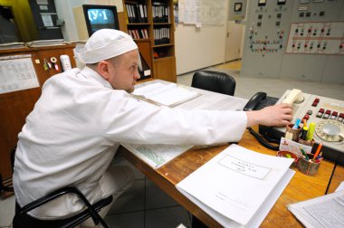 Control operations room of Chernobyl Nuclear Power Plant. Operator holding a receiver calling on the phone. April 20, 2018. Chernobyl, Ukraine