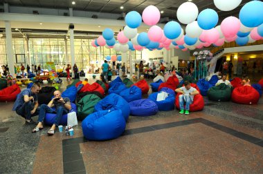 People sitting in bean bags relaxing at a lounge zone of a shopping mall. August 27, 2017. Kyiv, Ukraine