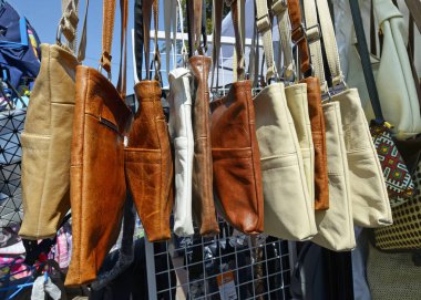 leather women's bags put up for sale at the street market stall tent.