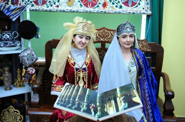 Young asian women in Tajik national costumes presenting stand of Tajikistan. Festival of Oriental culture. March 20, 2018. Kyiv, Ukraine clipart