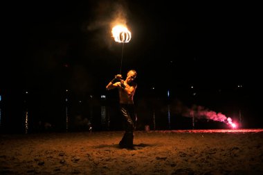 Geceleri kumlu sahilde hokkabazlık yapan bir adam. 11 Kasım 2019. Kyiv, Ukrayna