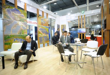 Diyalog kuruyorum. Solar Energy Trade Show 'daki bir sergide masaya oturan ve müzakere eden iş adamları. 19 Nisan 2019 Kiev, Ukrayna