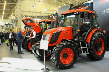 Modern traktörler park etmiş, insanlar etrafta dolaşıyor. Sergi AgroTrade Show-2019. 19 Şubat 2019. Kyiv, Ukrayna