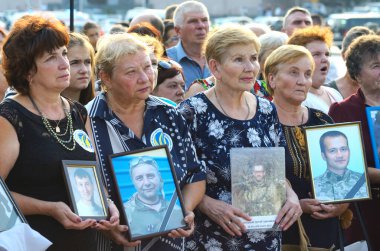 Yas tutan kadın anneler ve eşler ağlıyor ve ellerinde askerlerin portrelerini tutuyorlar. Ilovaisk savaşının yıldönümüne adanmış bir toplantı. 28 Ağustos 2018. Kyiv, Ukrayna