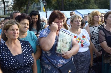 Yas tutan kadın anneler ve eşler ağlıyor ve ellerinde askerlerin portrelerini tutuyorlar. Ilovaisk savaşının yıldönümüne adanmış bir toplantı. 28 Ağustos 2018. Kyiv, Ukrayna