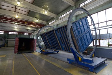 Kargo konteynırı tamir için dönen makinenin çerçevesine yerleştirildi. Konteynırların onarımı için bakım salonu, tren istasyonu tesisleri. Kyiv, Ukrayna