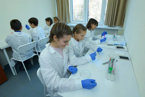 在学校化学实验室上化学课穿着实验室外套的学生用培养皿和镊子采集样品 2018年11月29日 乌克兰基辅 — 图库照片