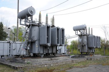 Transformatör, izolatörler ve bir elektrik santralinin yüksek gerilimli hatları.