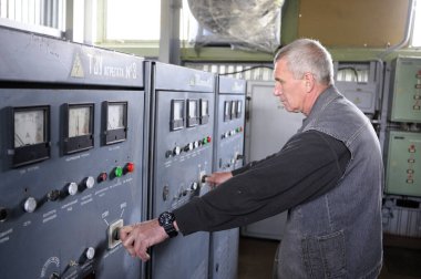 Kontrol operasyon odasında. İşçi, su tedarik sisteminin ana kontrol paneline takla atıyor. Medya için yüzen pompa istasyonu Rosa-300 'e basın turu. 5 Mayıs 2018. Oseschina, Ukrayna