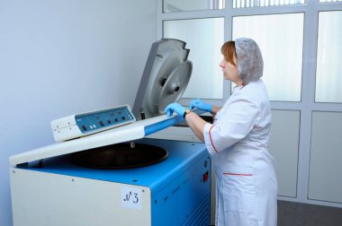 Santrifüjle çalışan kadın laboratuvar asistanı kan ayırma işlemine başlıyor. Belediyenin kan nakil istasyonu. 5 Nisan 2022. Kyiv, Ukrayna