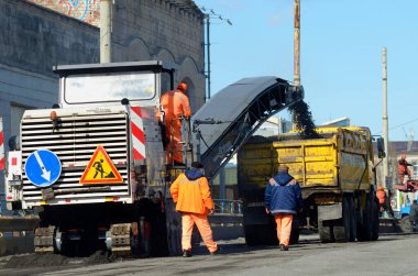 Yol profili: asfaltı kaldırıp kamyona yükleyen bir asfalt profilcisi Wirtgen. 17 Mart 2021. Kyiv, Ukrayna