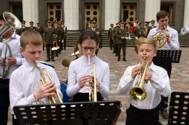 İki küçük oğlan ve kız trompet çalan bir bando bandosunun trompetçisi. Pirinç orkestraları festivali. 22 Ağustos 2018. Kyiv, Ukrayna