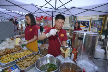 Asyalı aşçılar Asyalı sokak yemekleri restoranının mutfağında yemek pişiriyorlar. 15 Haziran 2021. Kyiv, Ukrayna