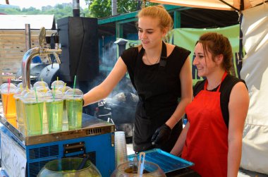 Sokak barmenleri müşteriler için bardaklara bira dolduruyor. 25 Temmuz 2019. Kyiv, Ukrayna
