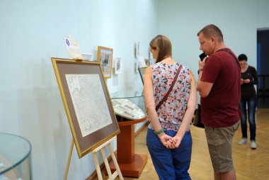 Kadın ve erkek bir sergiyi ziyaret ederken ellerinde objelerle tezgaha bakıyorlar. 5 Eylül 2021. Kyiv, Ukrayna