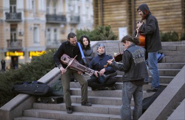 Gençler, sokak müzisyenleri, sokakta sitar, çello ve keman çalıyorlar. 23 Ekim 2019. Kyiv, Ukrayna