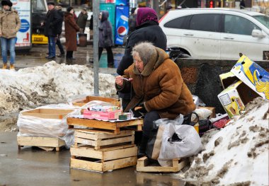 Yaşlı bir kadın, sigara sokak satıcısı, iş yerinde öğle yemeği yiyor. 23 Ocak 2016. Kyiv, Ukrayna